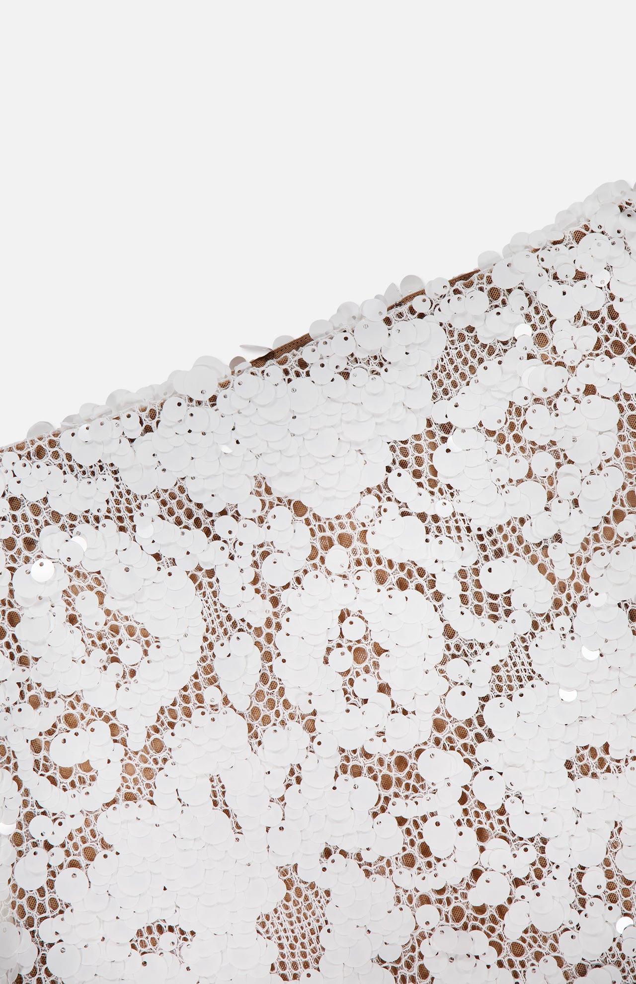 Close-up of the Makena Sequin Pencil Skirt by L'AGENCE, featuring white sequins in a lace-inspired pattern on sheer nude fabric. Its elegant, textured shine is ideal for chic bridal parties or sophisticated events.