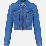 The Micah Oversized Denim Jacket by L’AGENCE is featured on a plain white background. This trendy blue denim jacket features long sleeves, a cropped silhouette, front zipper closure, and two chest pockets with flaps and buttons—delivering a stylish update to the classic denim jacket style.