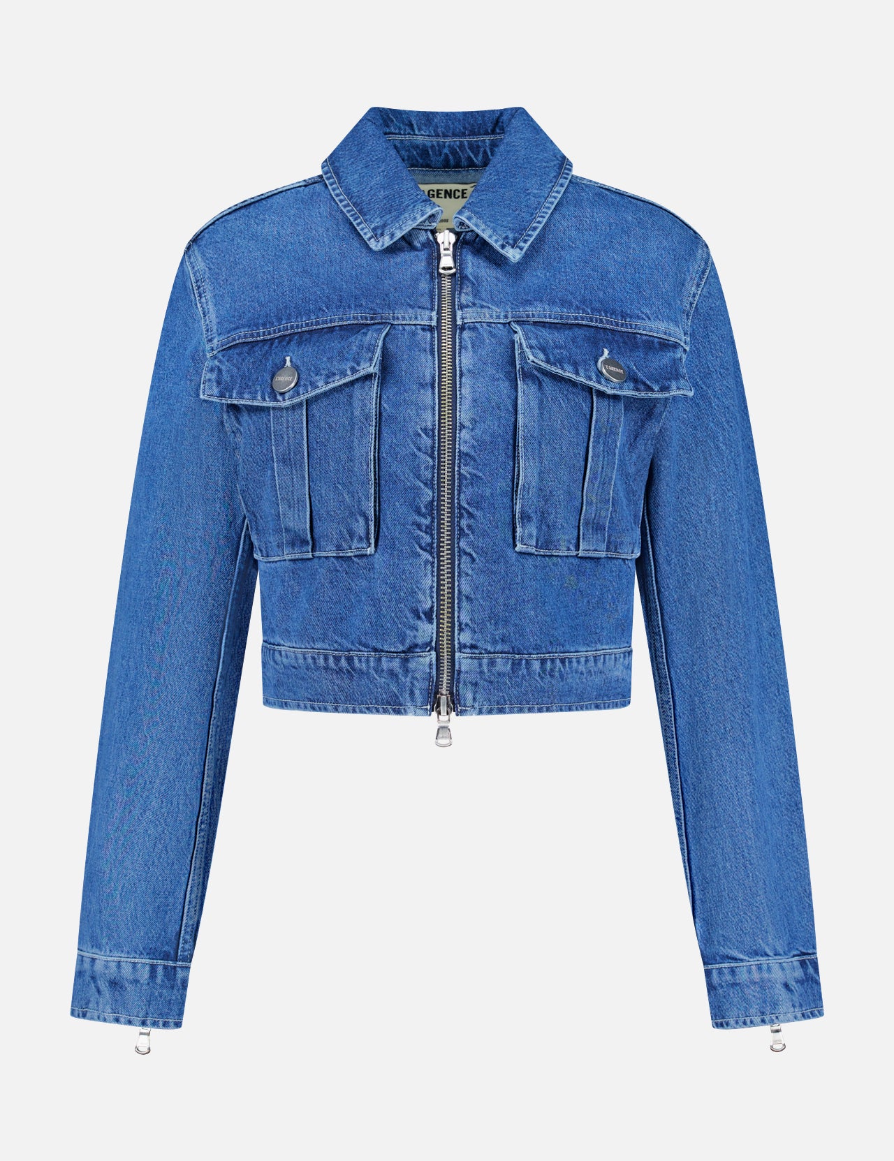 The Micah Oversized Denim Jacket by L’AGENCE is featured on a plain white background. This trendy blue denim jacket features long sleeves, a cropped silhouette, front zipper closure, and two chest pockets with flaps and buttons—delivering a stylish update to the classic denim jacket style.