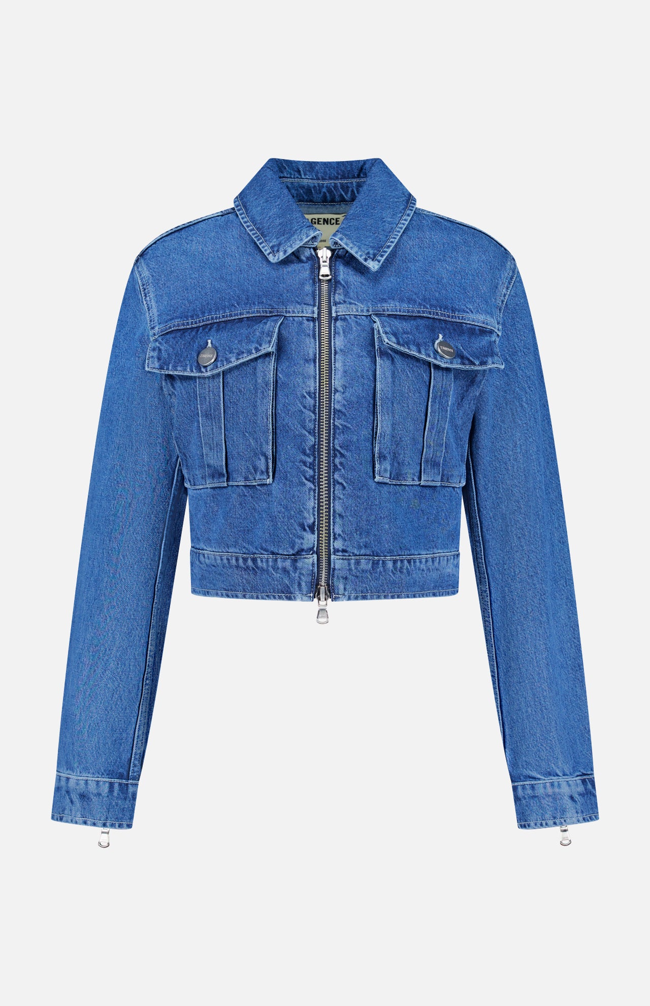 The Micah Oversized Denim Jacket by L’AGENCE is featured on a plain white background. This trendy blue denim jacket features long sleeves, a cropped silhouette, front zipper closure, and two chest pockets with flaps and buttons—delivering a stylish update to the classic denim jacket style.