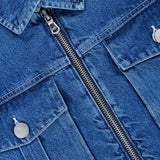 Close-up of the L’AGENCE Micah Oversized Denim Jacket in blue, featuring a front zipper closure and two front pockets with silver buttons. The texture and stitching details of the denim fabric are clearly visible.
