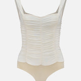 The L'AGENCE Mixie Ruched Bodysuit features vintage white mesh with wide straps, a square neckline, and snap-button crotch closure. Its upper is textured and gathered, while the lower part is smooth beige.