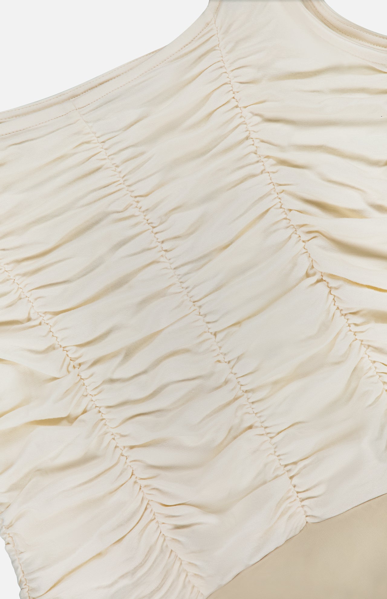 The Mixie Ruched Bodysuit by L'AGENCE features cream-colored stretch mesh with vertical gathered seams for a textured, slightly wrinkled look.