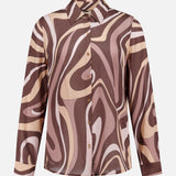 The Nina Long Sleeve Swirl Print Blouse by L'AGENCE features a brown, beige, and pink abstract swirl pattern, complete with a collared neckline and matching patterned cuffs.