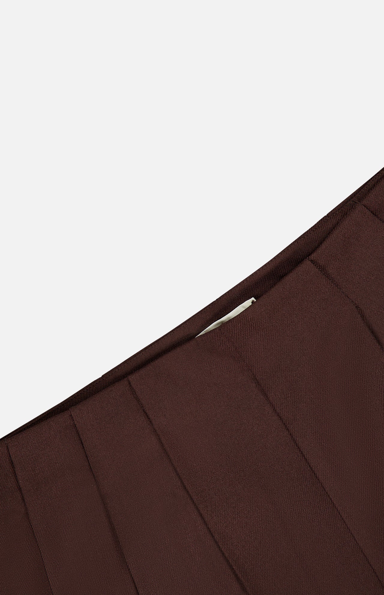 Close-up of the pleated waistband of dark chocolate brown, wide-leg L’Agence Nova Pleated Trouser Pant.