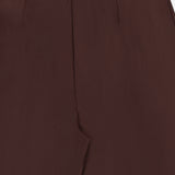 Close-up of the waist and front pleat detail of the L’Agence Nova Pleated Trouser Pant in dark chocolate brown.