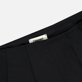 Close-up of the waistband on the black Novalynn Cropped Pleated Pant, featuring pleats and a white inner label with L'AGENCE branding in black.