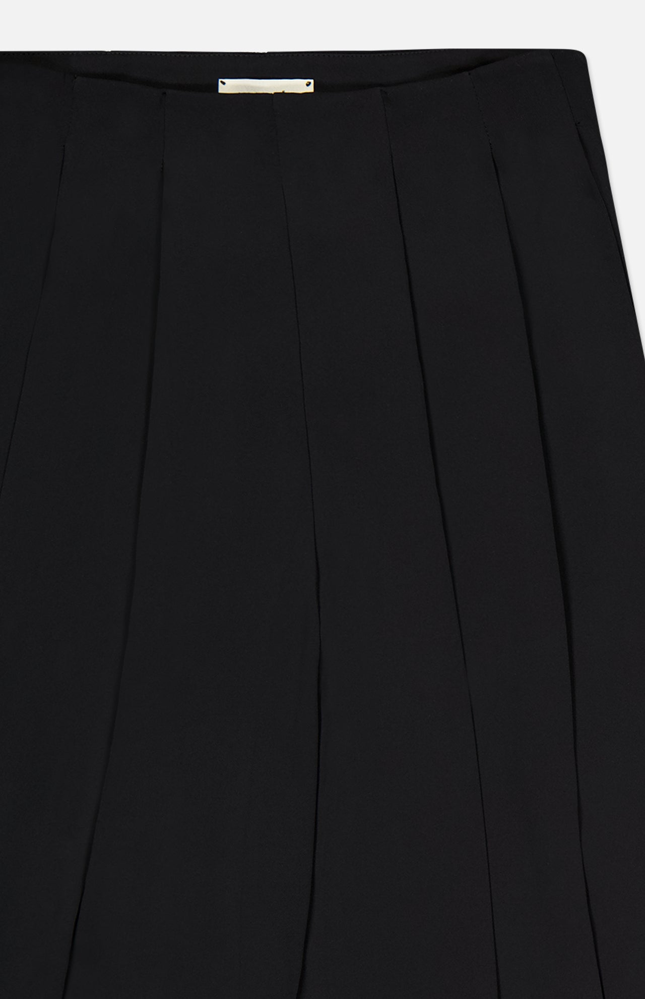 Close-up of the Novalynn Cropped Pleated Pant by L'AGENCE, featuring a black high-rise waistband, vertical pleats, smooth tailored fabric, and a small rectangular gold label at the waistband.