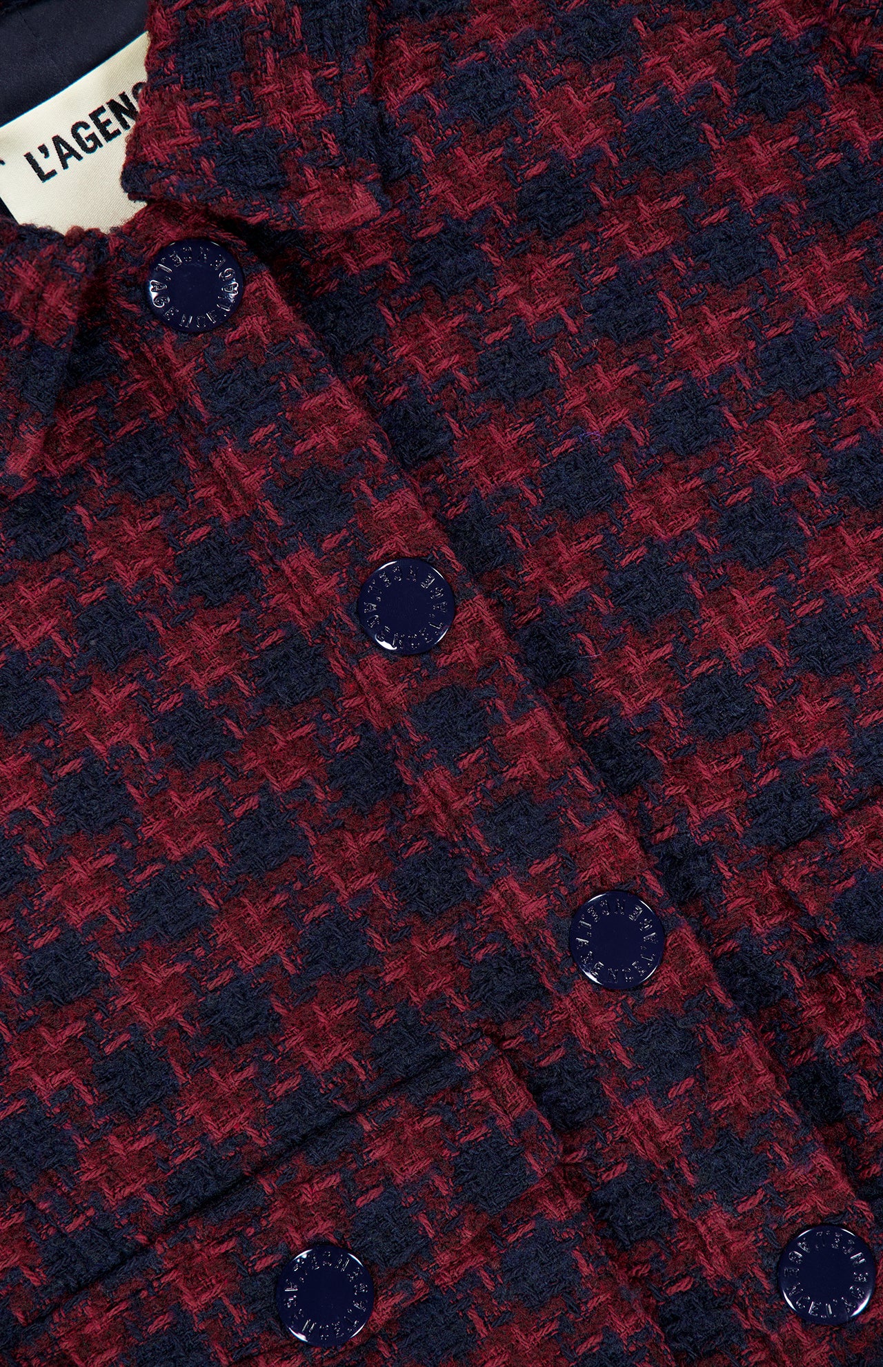 Close-up of the L’Agence NYX Cropped Tweed Jacket in a cotton-blend, burgundy and navy houndstooth pattern with dark blue buttons.