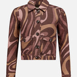 The Nyx Cropped Swirl Print Jacket by L'AGENCE is a long-sleeved, button-up style with a collar and two front pockets, showcasing an abstract swirl pattern in brown, tan, and pink for a modern sepia tone effect.