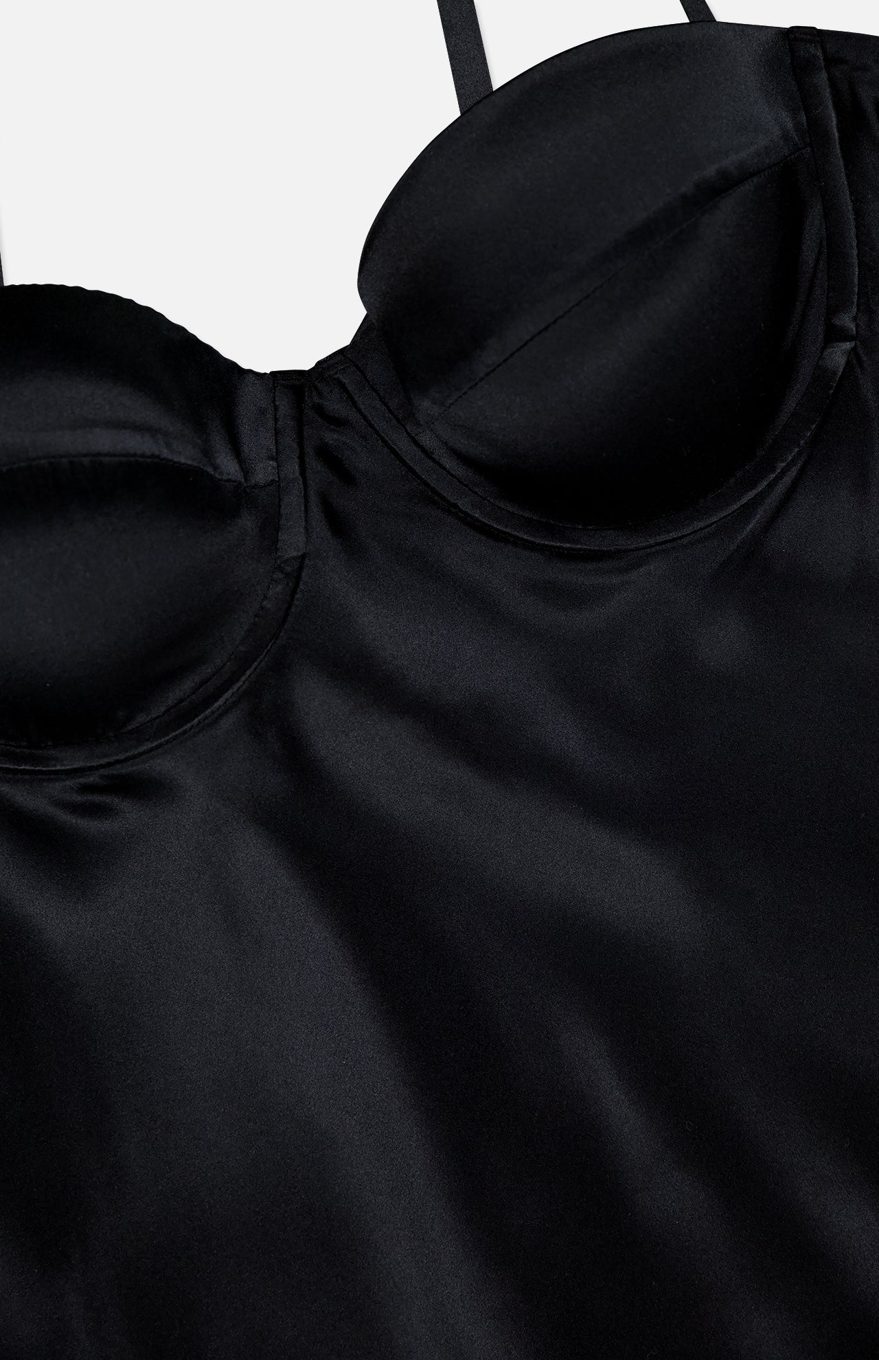 Close-up of the Orlina Silk Camisole Top by L'AGENCE, a black silk piece with underwire cups and thin straps, lingerie-inspired and set against a plain light background.