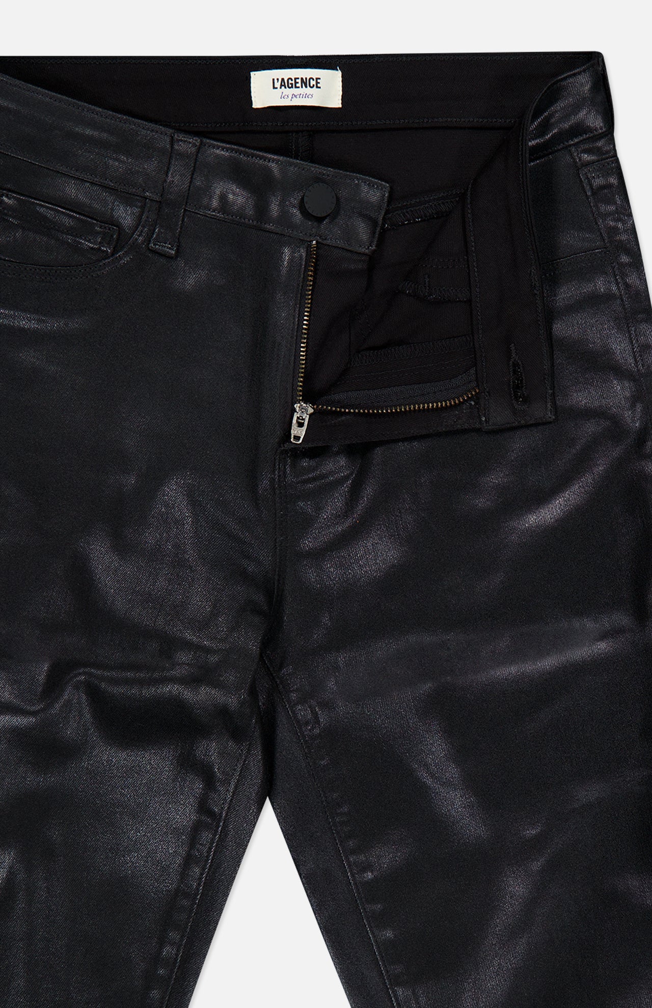 Petite Kendra High Rise Crop Flare in Noir by L’AGENCE features a black coated denim fabric with a metallic sheen, classic five-pocket styling, and a modern cropped flare silhouette. The pants have a partially open zipper and button, revealing a black waistband label that reads L’AGENCE.