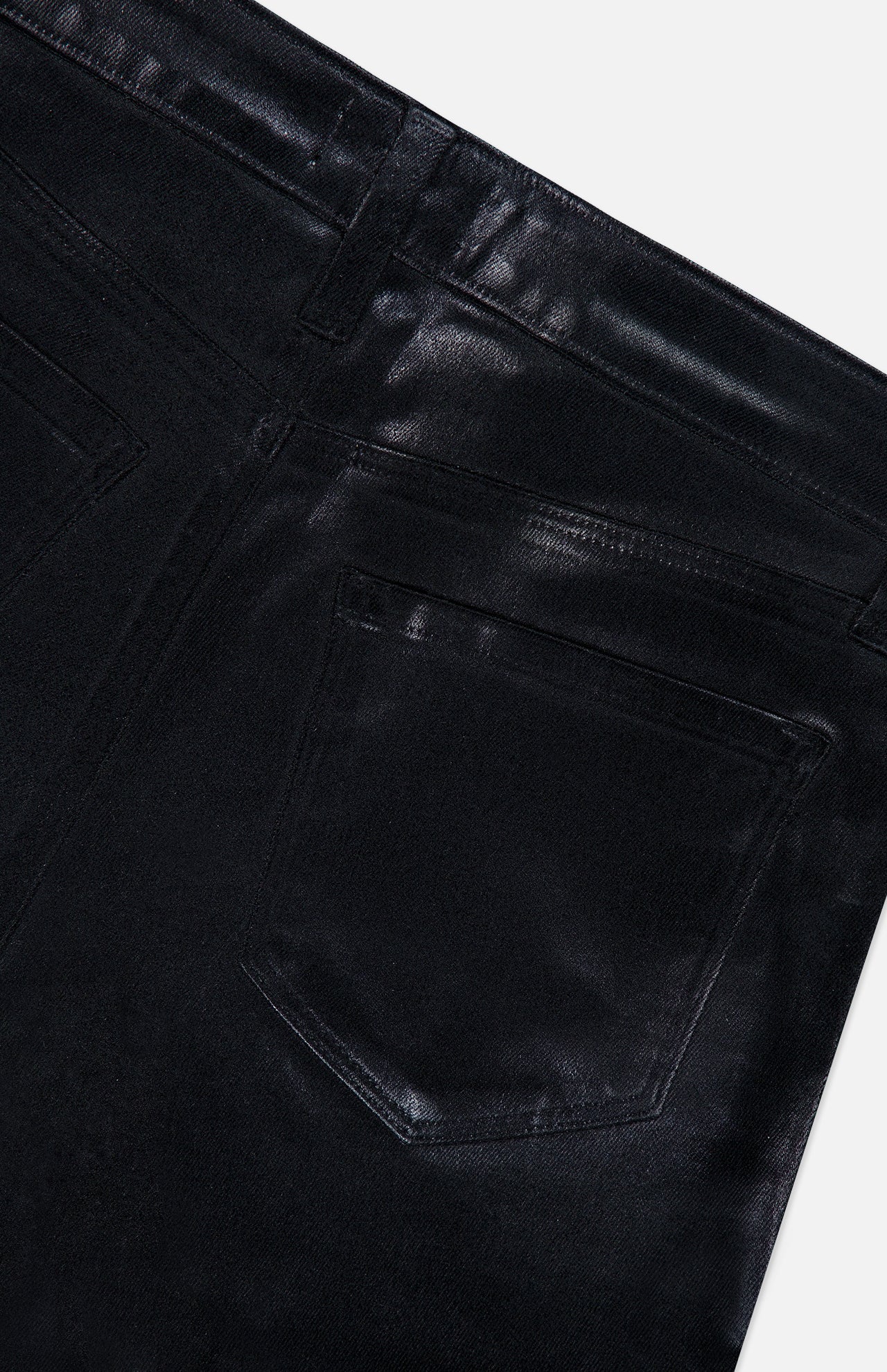 Close-up of the back pocket and waistband of the L’AGENCE Petite Kendra High Rise Crop Flare in Noir, highlighting stitching details, belt loops, and the slightly shiny black coated denim texture.