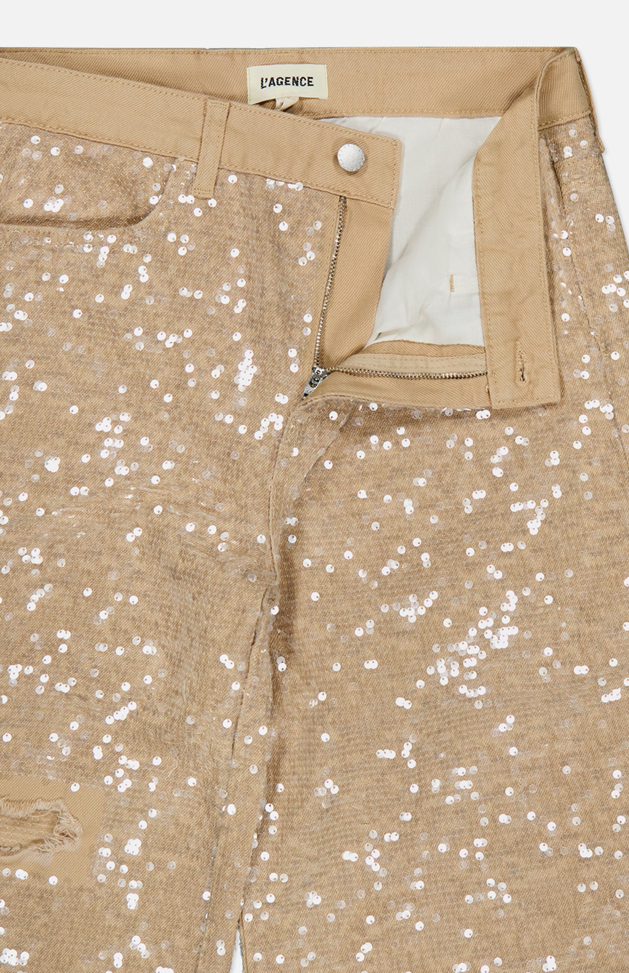 Close-up of Quincy Sequin High Rise Wide Leg Pant by L’AGENCE in distressed beige with visible zipper, button closure, and label. The high-rise, wide-leg pants are partially unzipped to show the white pocket lining.