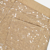 Close-up of the back pocket and waistband of the Quincy Sequin High Rise Wide Leg Pant by L’AGENCE, featuring tan fabric adorned with silver sequins for a sparkling, textured look.