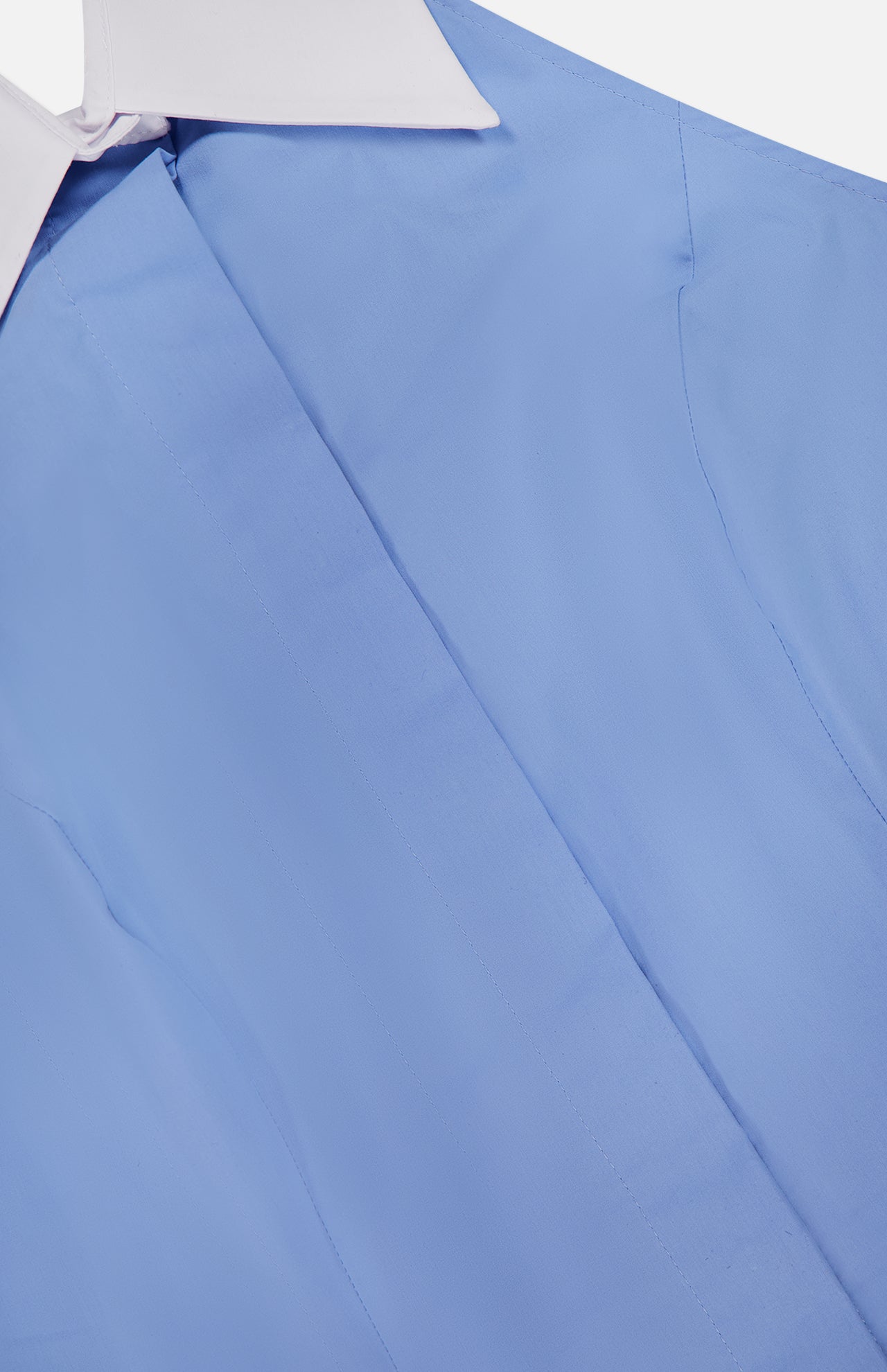 Close-up of the Rina Collared Halter Top by L'AGENCE in light blue poplin, featuring a white pointed collar; shown from an angle highlighting the front and part of the sleeve. The top is neatly pressed and buttoned.