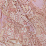 Close-up of the L'AGENCE Rosette Paisley Print Maxi Dress in pink with beige patterns and fabric-covered buttons along a gathered seam on the fitted bodice.