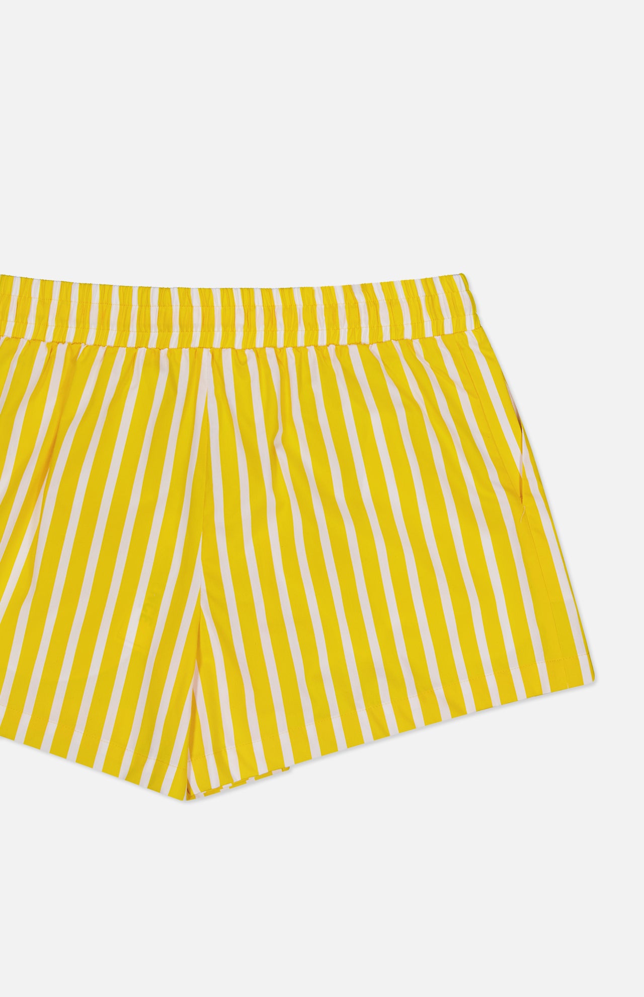 The Royce Drawstring Stripe Short by L'AGENCE features yellow and white stripes on organic cotton poplin with an elastic waistband. Only the upper half of these shorts is shown against a white background.