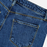 Close-up of the back pocket and waistband of the Ruth High Rise Straight Jean in Newcastle by L’AGENCE, crafted from blue premium stretch denim, featuring detailed stitching and a single belt loop, isolated on a white background.