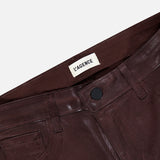 Close-up of shiny burgundy coated Ruth High Rise Straight Pant by L’AGENCE, featuring a black button and visible L’AGENCE label on the inside waistband against a white background; these high-rise pants showcase a slim, straight-leg silhouette.