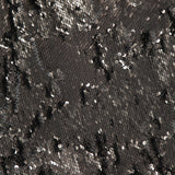 A close-up of the Sayla Bias Cut Sequin Maxi Dress by L'AGENCE showcases its fabric adorned with gleaming black and silver sequins, creating a shimmering, textured surface that radiates vintage glamour—ideal for making a statement at any event.