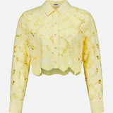 The Seychelle Cropped Button Down Shirt by L'AGENCE is a sheer yellow lace, long-sleeve, collared blouse with floral pattern—perfect as a light summer top.