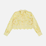 The Seychelle Cropped Button Down Shirt by L'AGENCE is a sheer, long-sleeved yellow blouse with gold floral embroidery and scalloped edges, shown flat on a white background in back view.