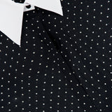 Close-up of the Sona Poplin Collar Blouse by L’AGENCE, featuring a black base adorned with small white polka dots and finished with a crisp white collar for an effortlessly chic look. The partially visible label at the neckline adds a subtle touch to this office-appropriate top.