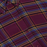 Close-up of the L’Agence Suzette Hi Low Shirt in a purple, blue, and yellow plaid pattern with metallic thread accents, a high-low hem, and a back slit detail.
