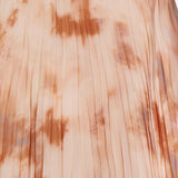 A close-up of the L'AGENCE Torin Pleated Maxi Skirt, featuring vertical pleats and a soft peach and tan frappe tie-dye pattern with delicate color variations.