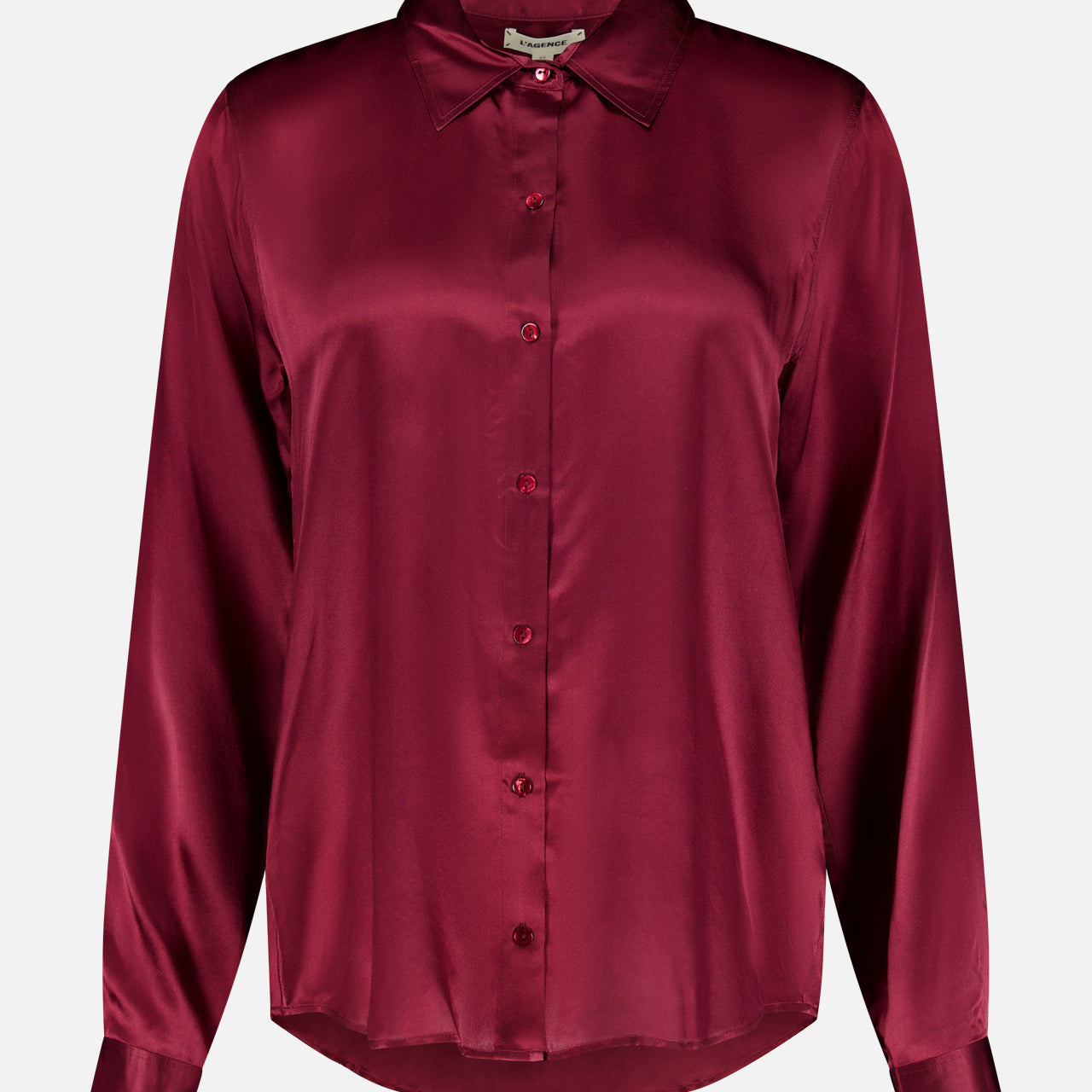 The Tyler Long Sleeve Silk Blouse by L’AGENCE is crafted in luxurious silk with a classic collar, button-up front, and a rich merlot red hue that gives it a smooth, lustrous finish.