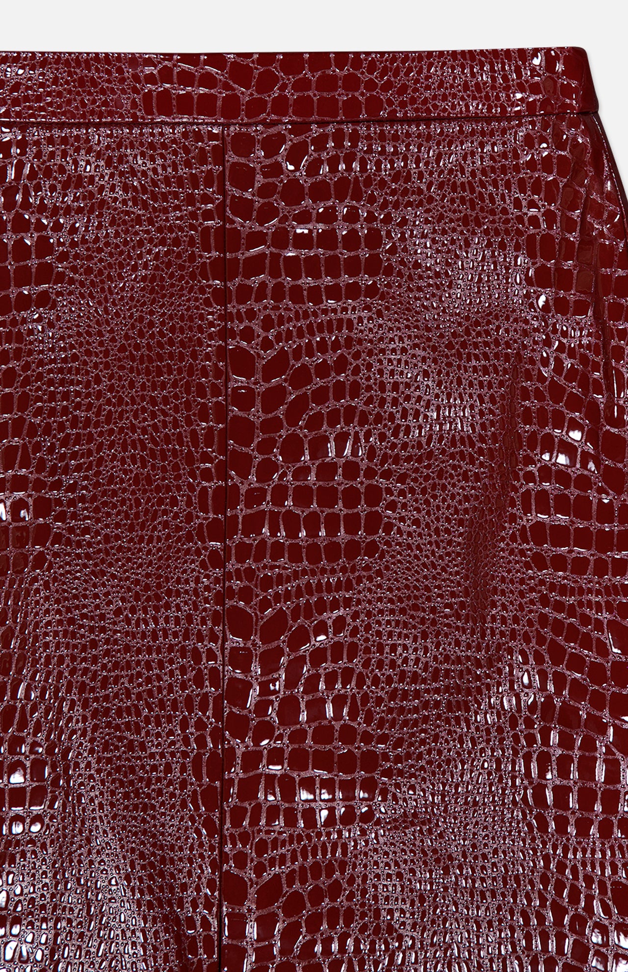 Close-up of the Violetta Pencil Skirt by L’AGENCE, showcasing its glossy, richly textured burgundy croc-embossed vegan leather with visible seam lines—perfectly reflecting the skirt’s luxurious allure.
