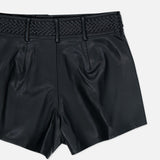 The L’AGENCE Virelle Braided Waistband Short features black vegan leather, a high waist, pleated front, and a distinctive braided waistband detail at the top, displayed against a plain white background.
