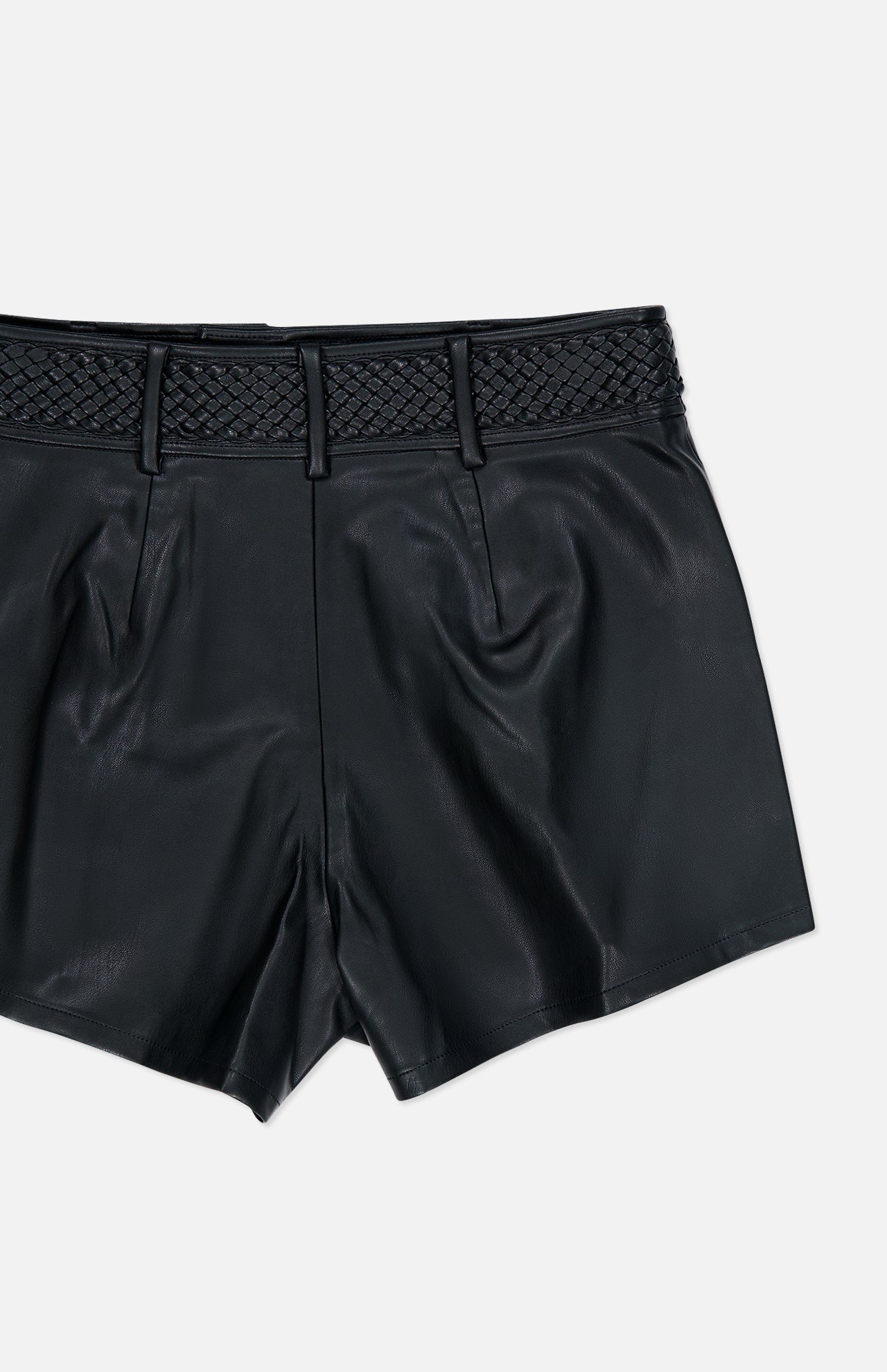The L’AGENCE Virelle Braided Waistband Short features black vegan leather, a high waist, pleated front, and a distinctive braided waistband detail at the top, displayed against a plain white background.