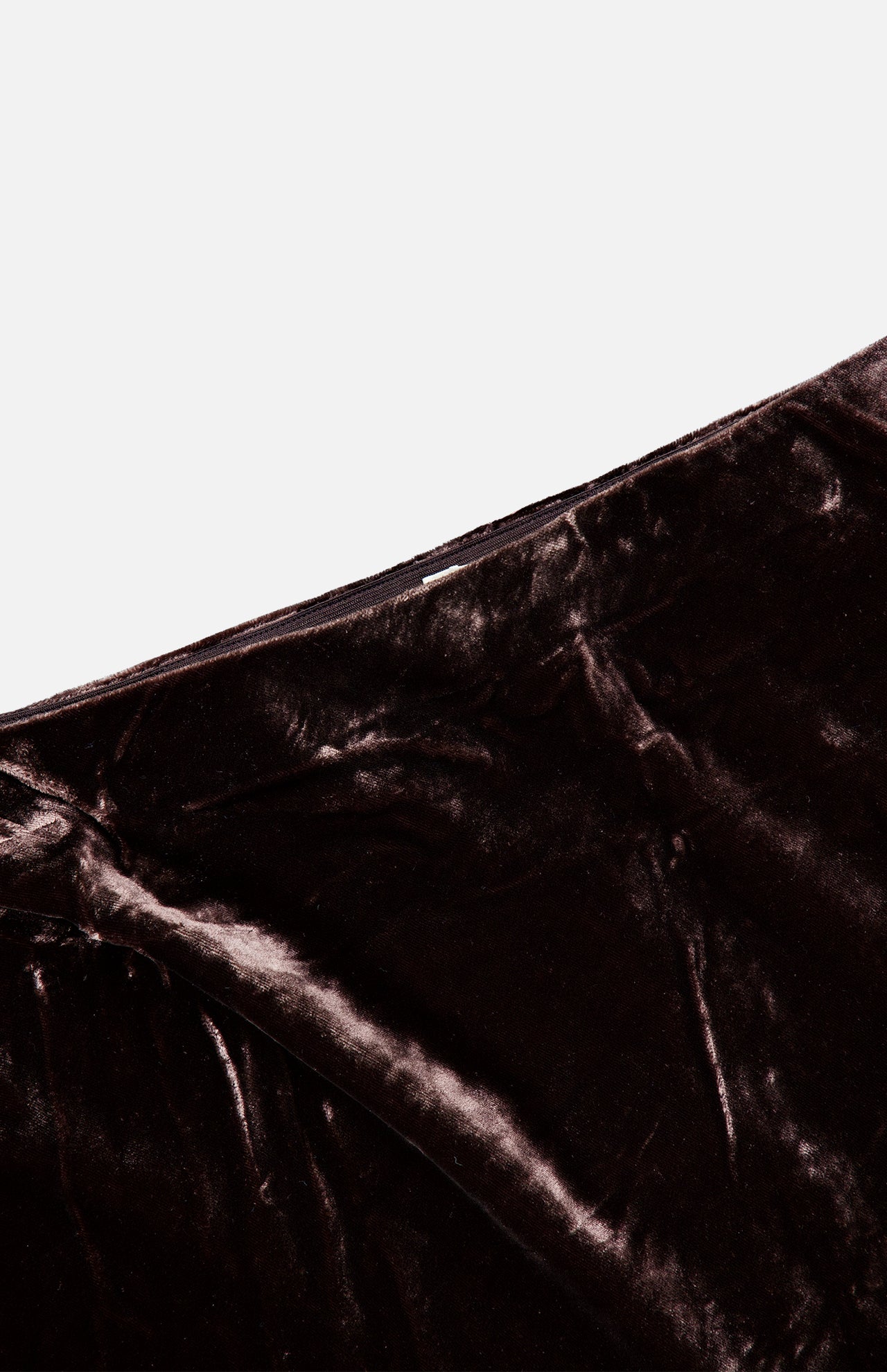 Close-up of a dark brown L’Agence Zeta Long Velvet Skirt featuring a bias-cut design.