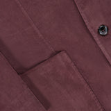 Close-up of the L.B.M. Corduroy Single Breasted Sportcoat in maroon, highlighting a front pocket, part of a sleeve, and two black buttons. The texture and fine ridges of the cotton corduroy fabric are clearly visible.