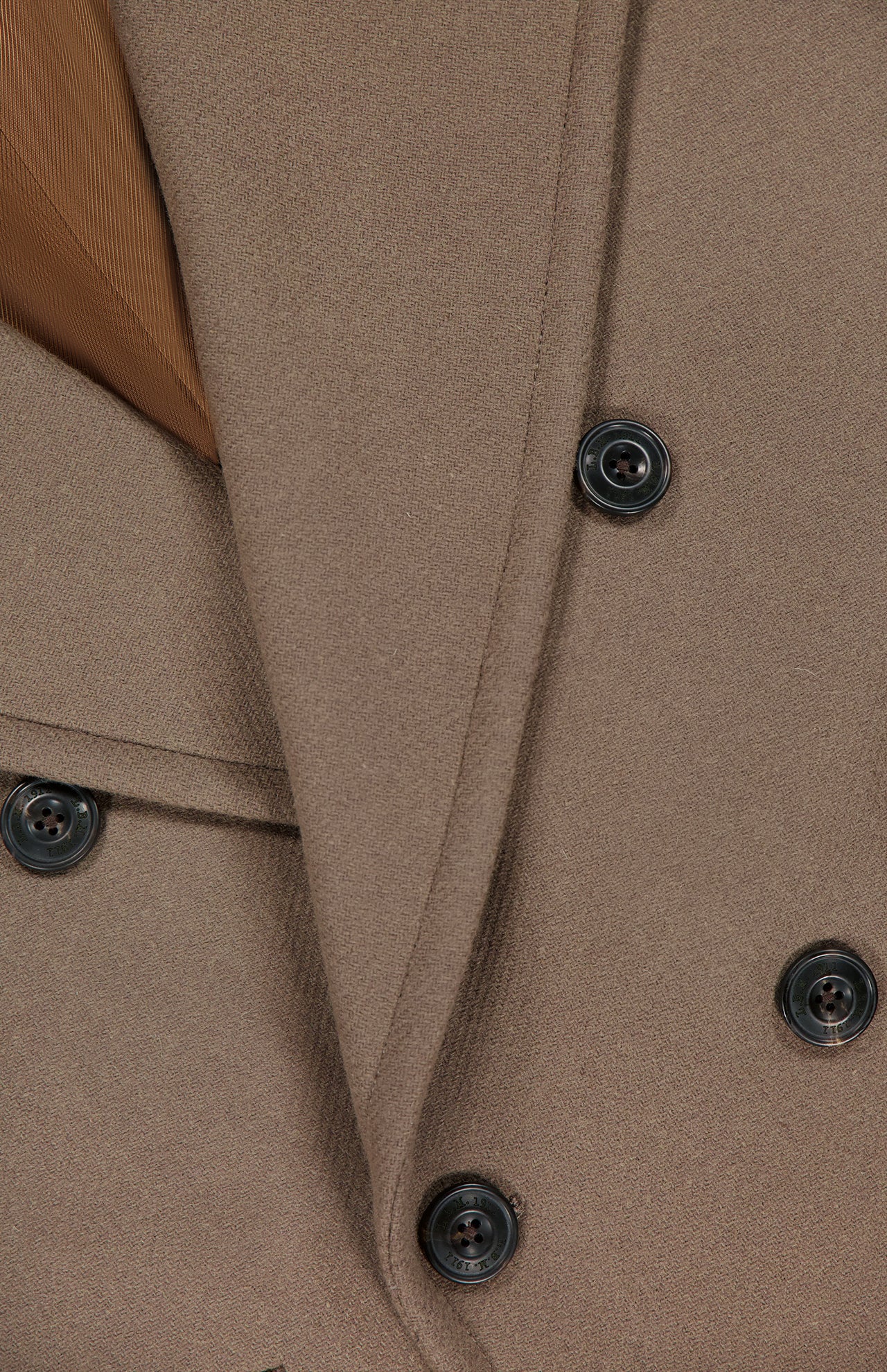 Close-up of the L.B.M. Double Breasted Car Coat in brown, featuring four black buttons and overlapping fabric lapels with a hint of lighter brown inner lining—an elegant Italian-made piece.