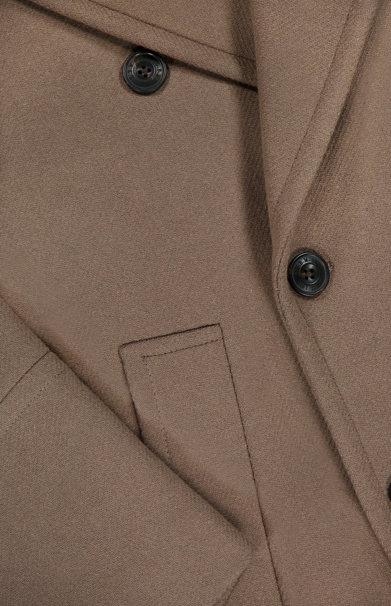 Close-up of the L.B.M. Double Breasted Car Coat in brown, crafted from a wool-blend and featuring two black buttons, sharp lapels, and a neatly stitched pocket. The fabric's texture and tailored details are clearly visible, highlighting the refined craftsmanship typical of Italian-made pieces.