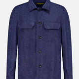 The L.B.M. Glen Plaid Overshirt is a long-sleeve, button-up shirt crafted from a linen-wool blend, featuring a blue checkered pattern, two chest pockets, and a classic collar, shown against a plain white background.