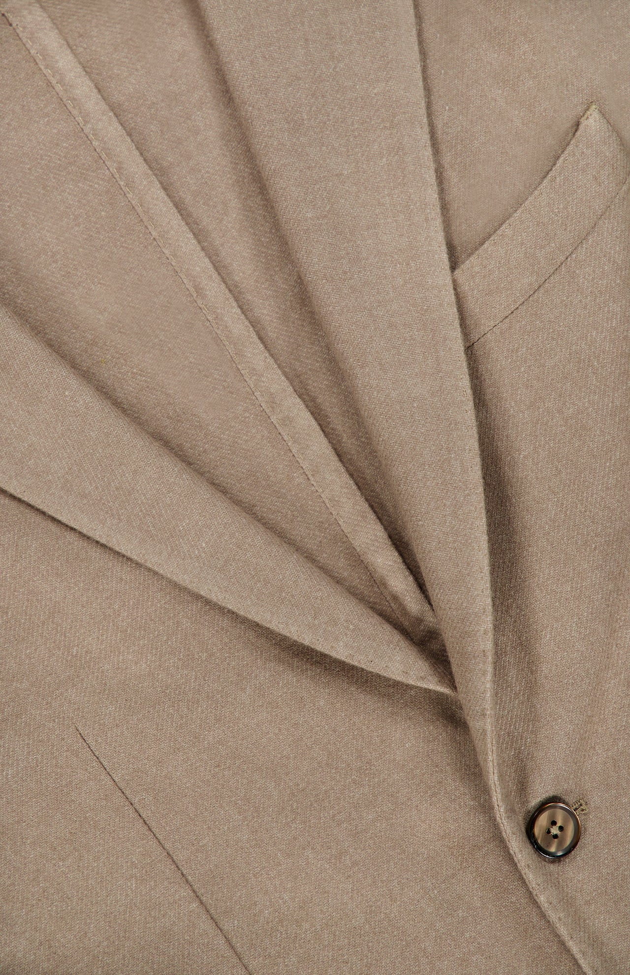 Close-up of the L.B.M. Solid 2 Button Sportcoat in beige wool cashmere, made in Italy, highlighting the lapel, pocket, and one of the brown buttons. The fine texture of the fabric is visible, showcasing the sportcoat’s precise tailoring.