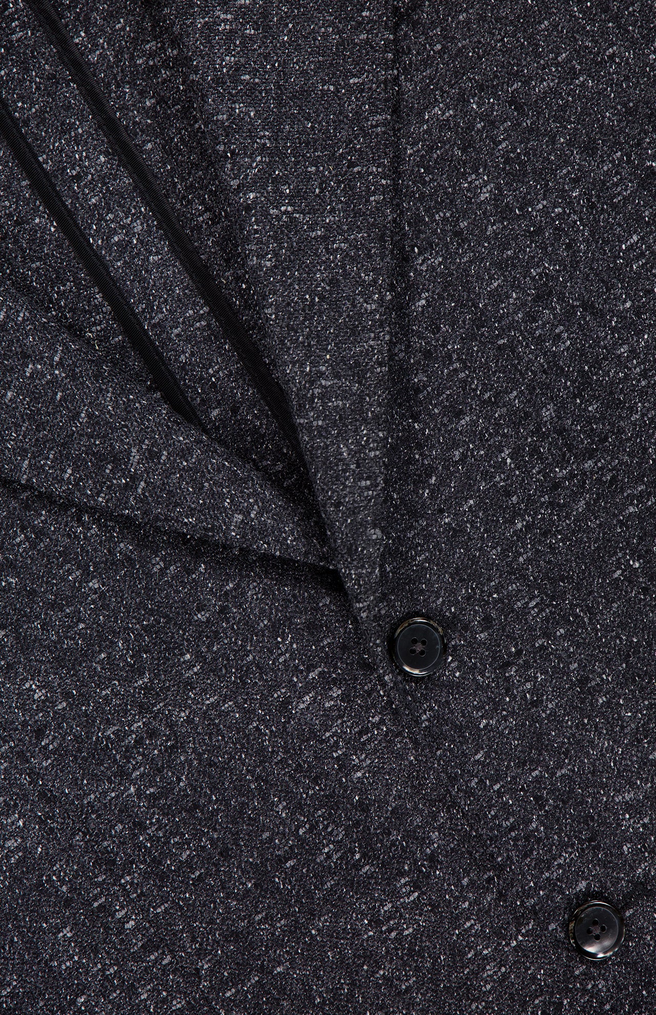 Close-up of the L.B.M. Speck 2 Button Sportcoat in textured dark grey, featuring two black buttons and a visible pocket. Fine speckled details highlight the expert Italian craftsmanship, making this an elegant and refined piece.