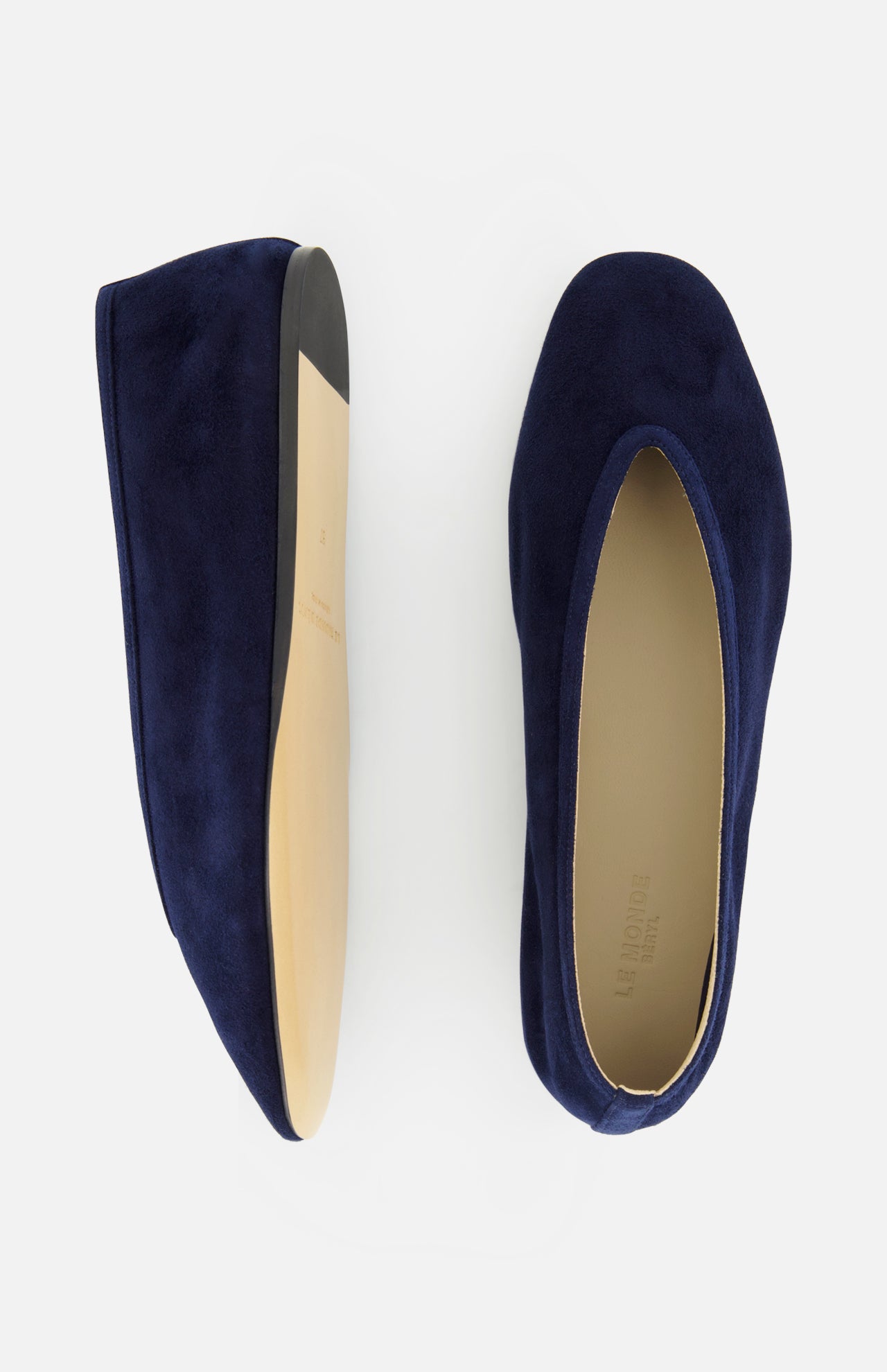 The Luna Suede Slipper Flat by LE MONDE BERYL is a pair of dark blue suede slip-on ballet flats with tan soles, shown from side and top views on a white background. Expertly crafted in Italy.