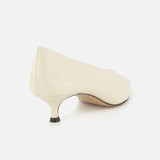 The Babouche Leather Kitten Heel by LE MONDE BERYL is shown from the back, featuring a cream-colored design with a rounded toe and kitten heel against a white background.