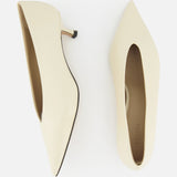A pair of LE MONDE BERYL Babouche Leather Kitten Heels in off-white, shown from above on a white background—one shoe displays the side profile, the other shows the top view.