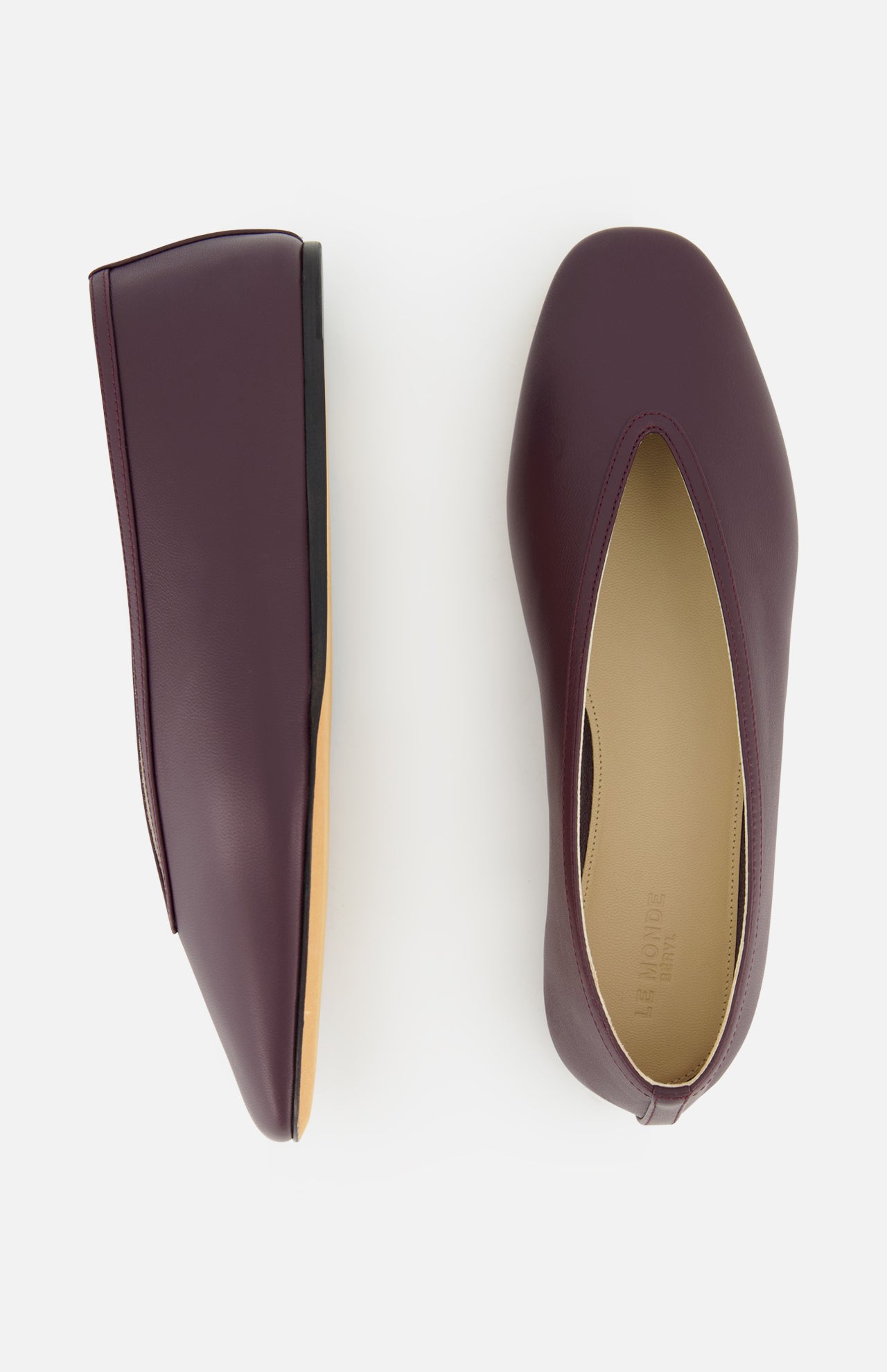 Le Monde Béryl Luna Leather Slipper Flat: a pair of handcrafted dark burgundy leather flat slippers with a V-cut vamp, shown from the top and side.