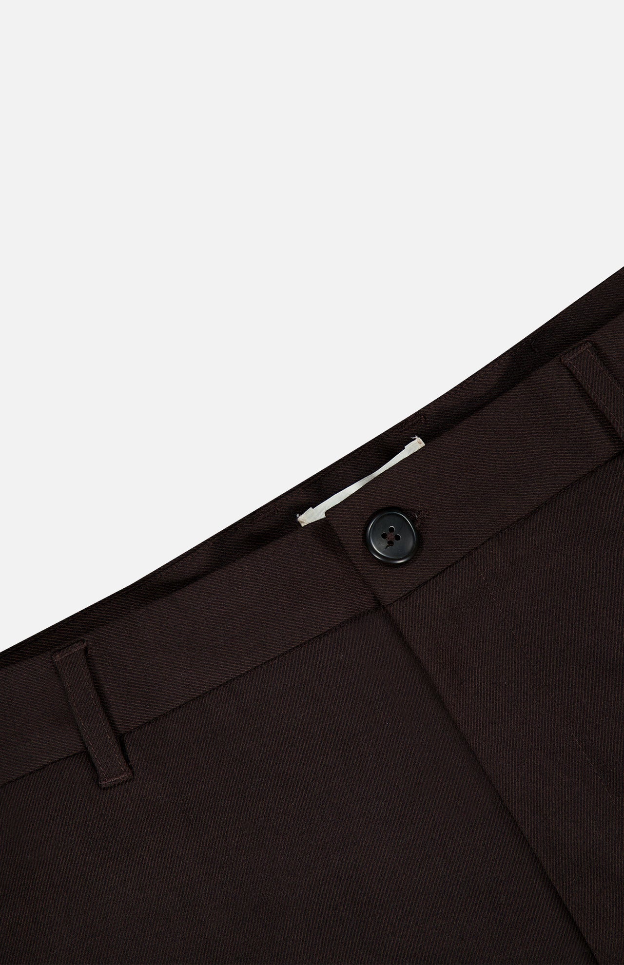 Close-up of the waistband of the LES DEUX Brushed Twill Regular Suit Pants in dark brown, highlighting the brushed twill fabric, black button, belt loops, and part of the zipper fly against a plain light background.