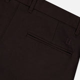 Close-up of the back pocket area of the LES DEUX Brushed Twill Regular Suit Pants in dark brown, crafted from brushed twill fabric, featuring a single welt pocket, belt loops, and a subtle embroidered II logo near the pocket.