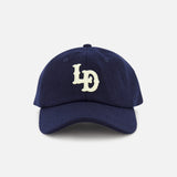 A navy blue LES DEUX Felt Logo Dad Cap with white “LD” letters embroidered on the front, displayed against a plain white background.