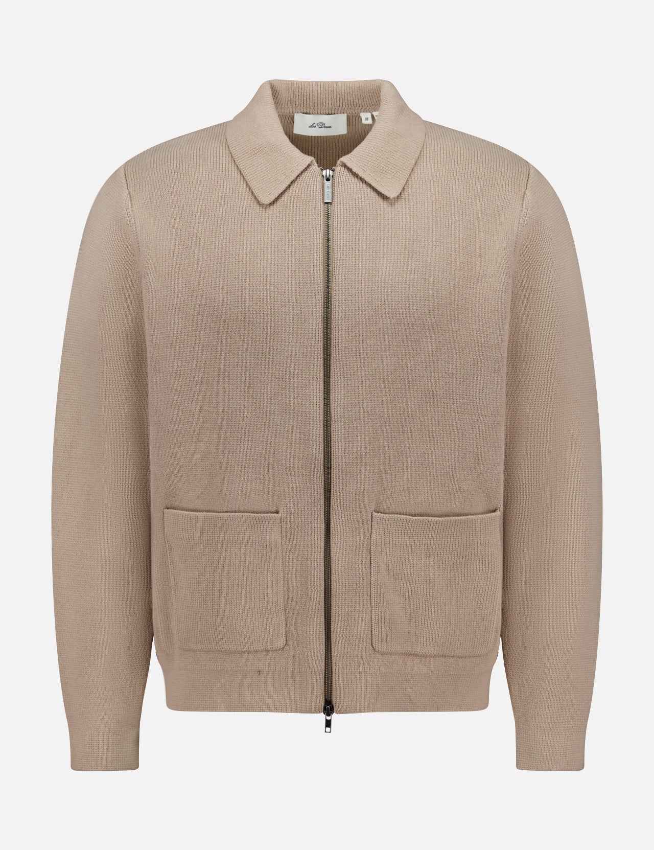 The LES DEUX Fischer Cotton Milano Zip Overshirt is a beige, collared zip-up with two front pockets, made from durable structured knit, shown against a plain white background.