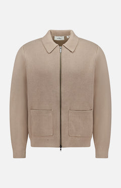 The LES DEUX Fischer Cotton Milano Zip Overshirt is a beige, collared zip-up with two front pockets, made from durable structured knit, shown against a plain white background.